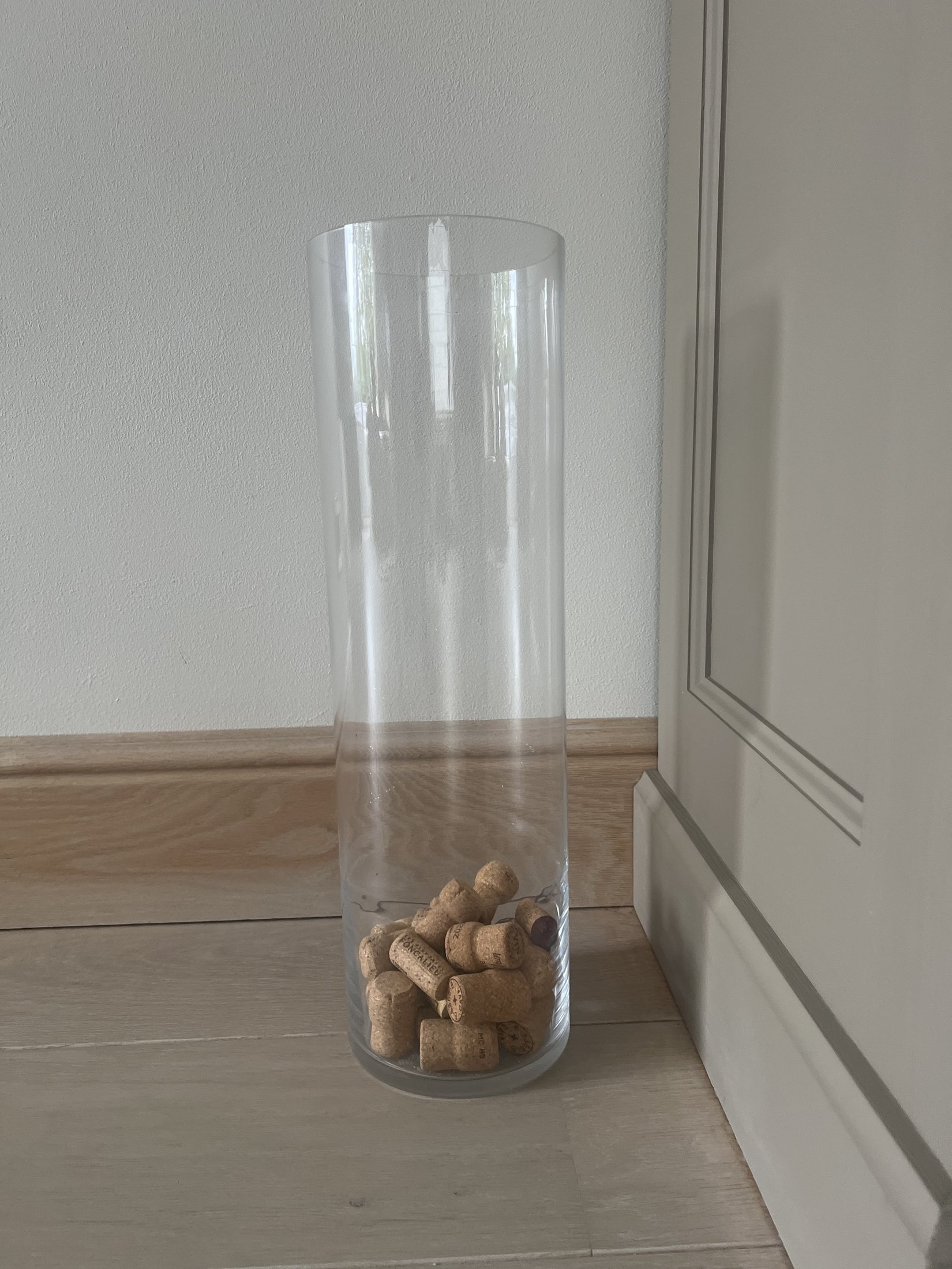 Hoge transparante glazen vaas met kurken