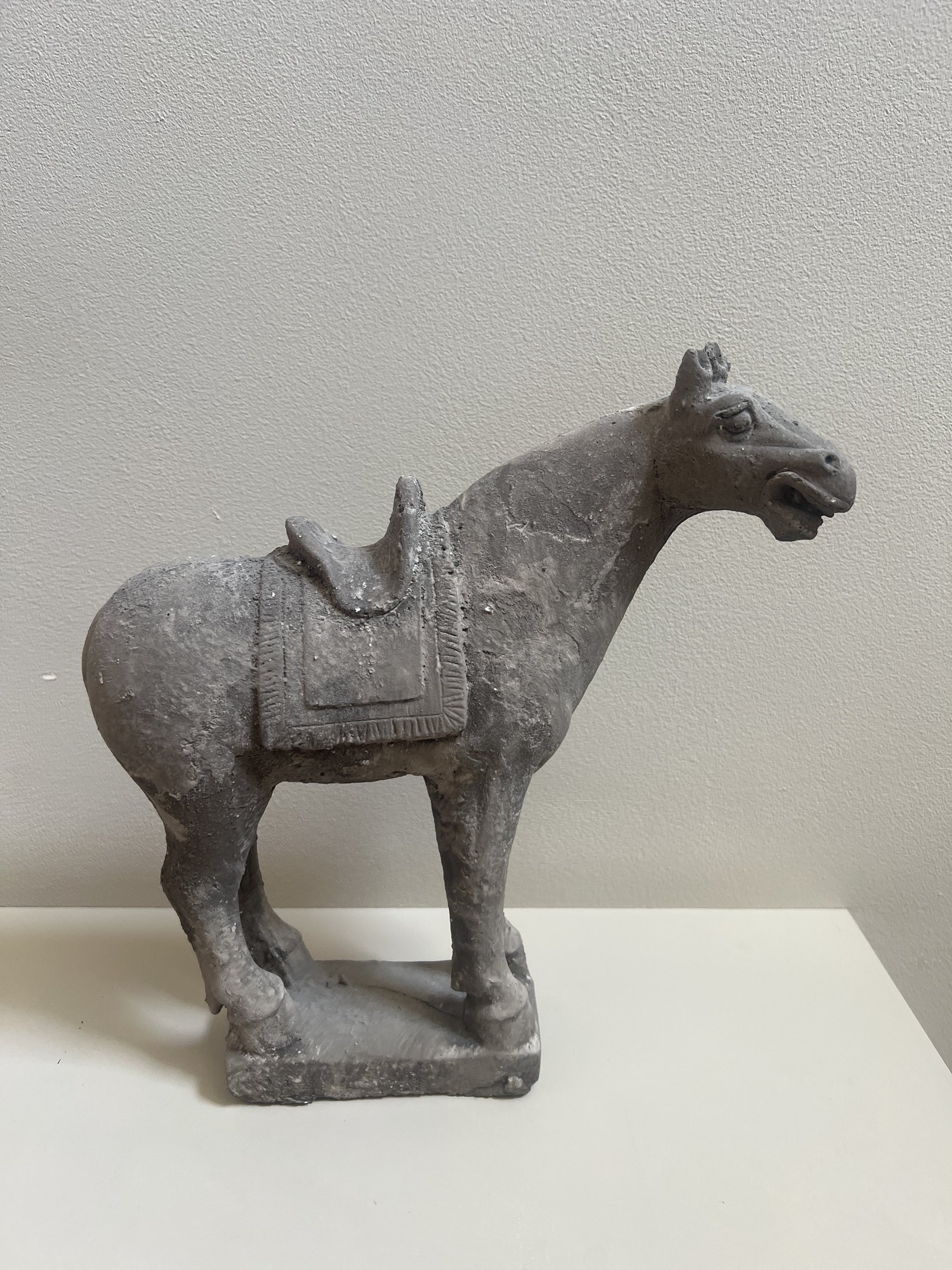 Grijs paardenbeeld met zadel